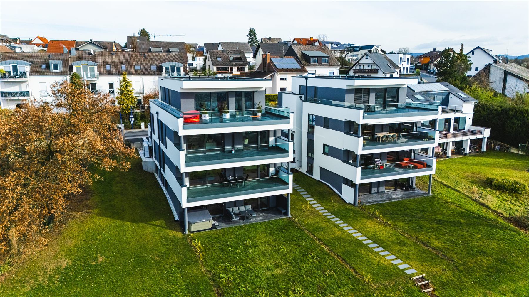 Luftaufnahme des modernen Wohngebäudes mit umlaufenden Glasbalkonen