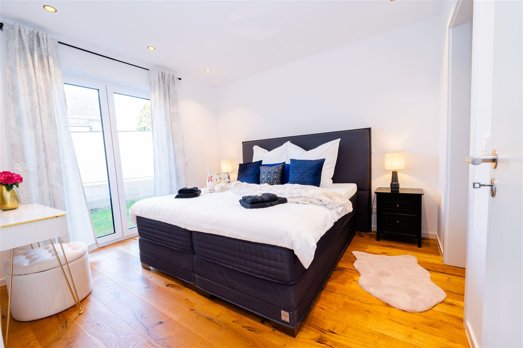 Hauptschlafzimmer mit Boxspring-Doppelbett und Zugang zum Garten
