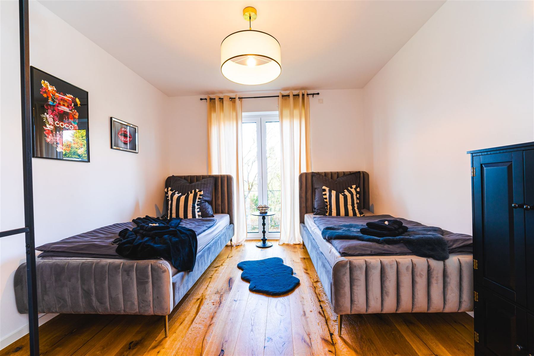 Schlafzimmer mit zwei Einzelbetten und Kunstdrucken