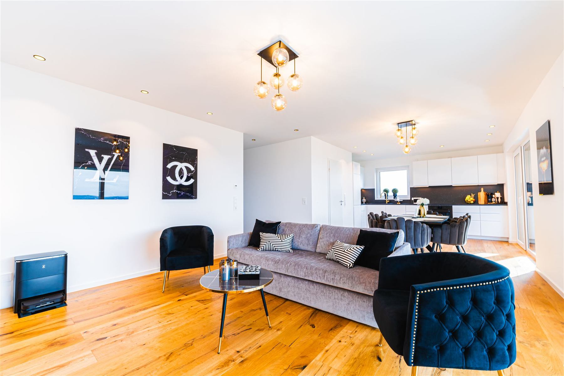 Lounge-Ecke mit dunklen Samtsesseln und Kunstobjekten