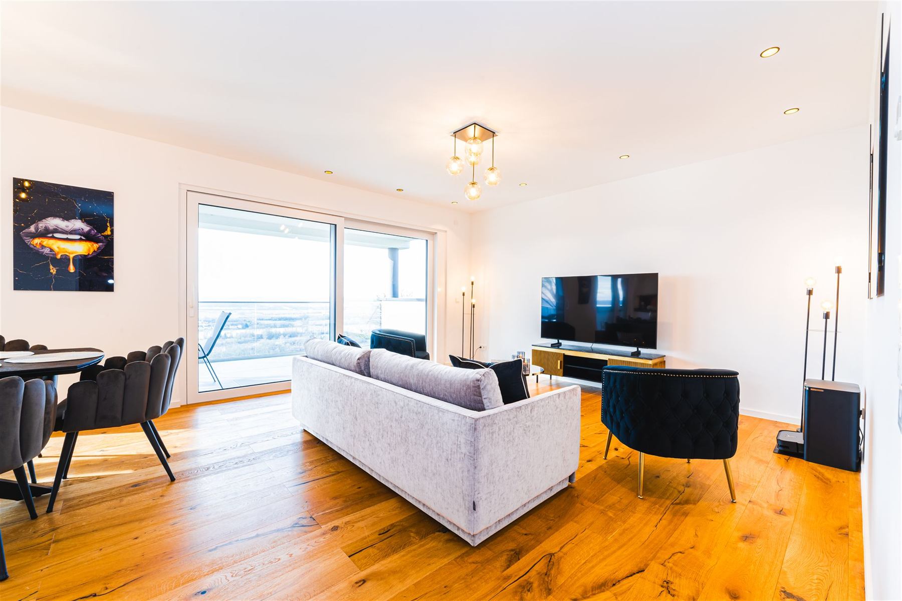 Helles Wohnzimmer mit ausziehbarem Schlafsofa, Loungesesseln und Blick zur Terrasse